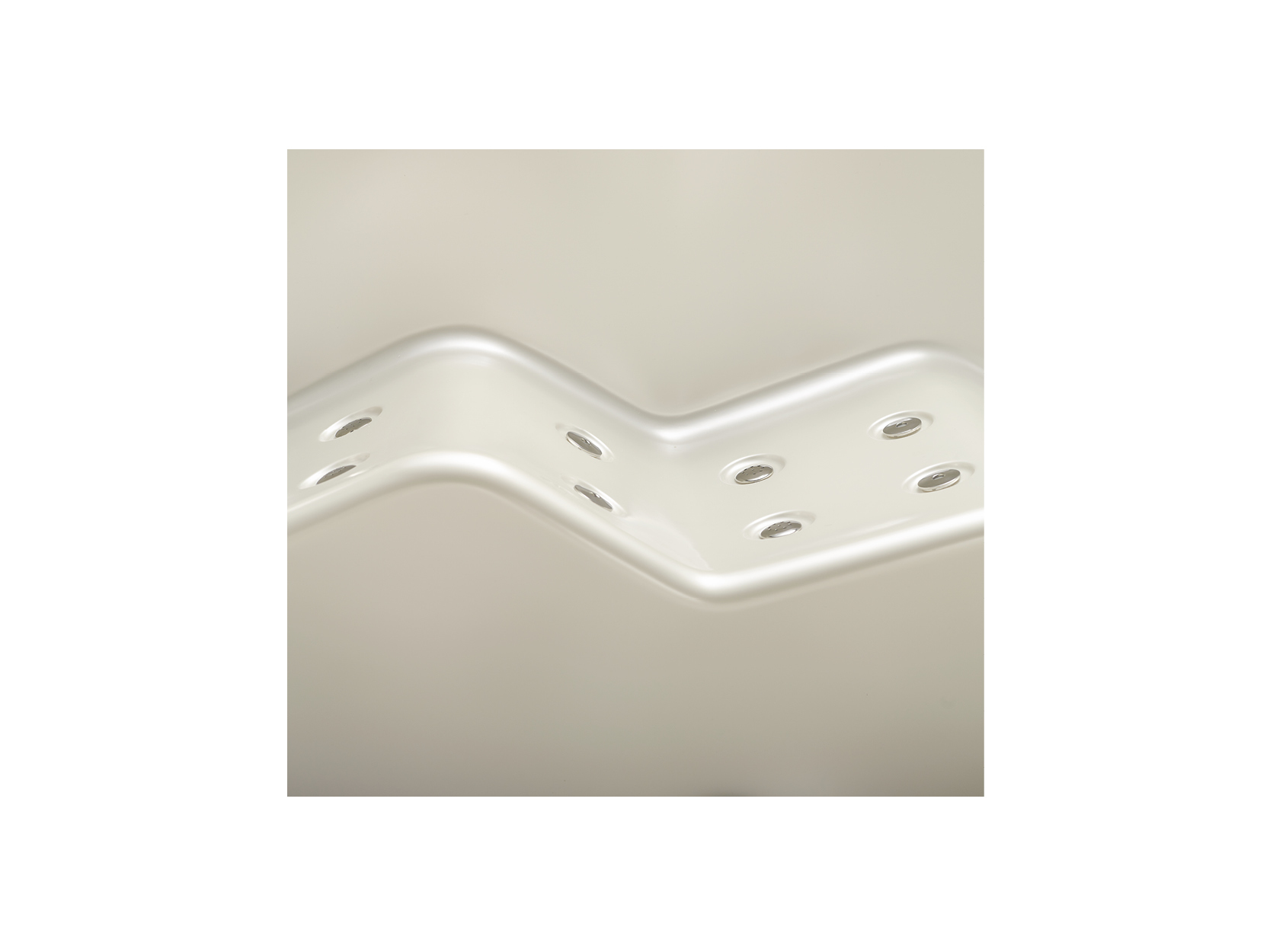 Nahaufnahme der wellenförmigen, weißen Oberfläche eines USSPA® Premium-Whirlpools mit integrierten Hydrotherapie-Düsen für entspannende Massagen.