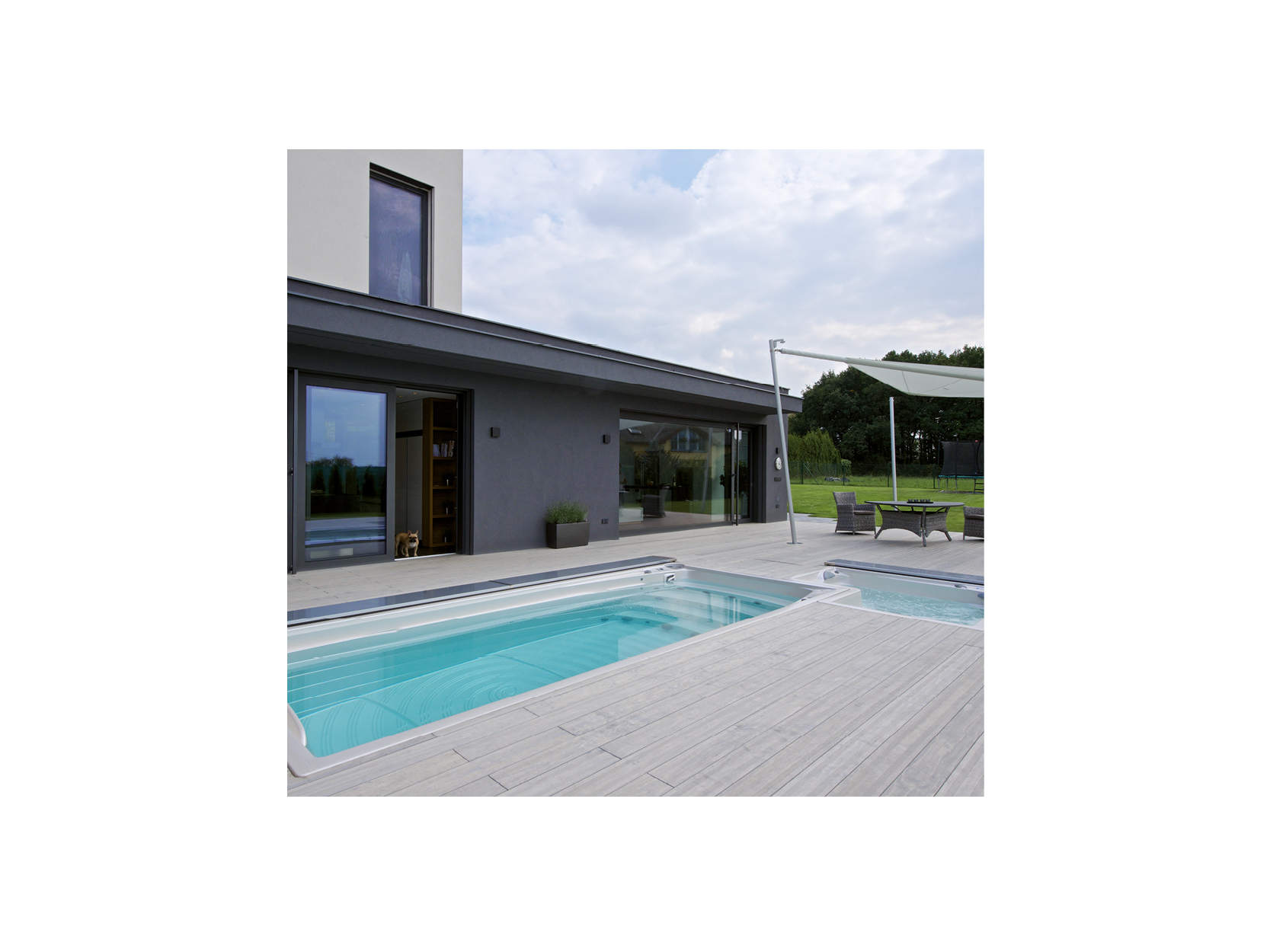 Ein moderner Außenbereich mit einer hochwertigen Swim-Spa- und Whirlpool-Kombination von USSPA – realisiert von der ActiveSpa GmbH –, platziert auf einer eleganten Terrasse neben einem zeitgenössischen Wohnhaus; ideal für Entspannung und Fitness.
