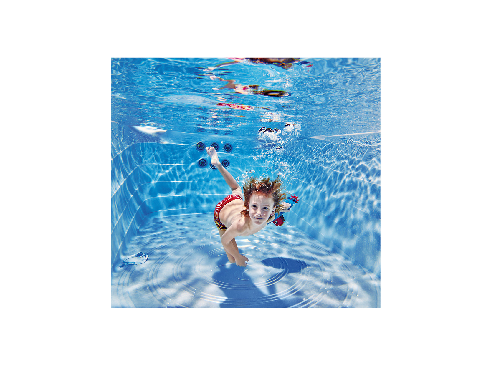 Kind schwimmt unter Wasser in einem klaren, blauen Premium-Swim-Spa von ActiveSpa – ideal für private Entspannung und Fitness.